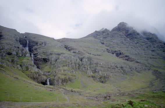 A waterfall running down the worn mountainside