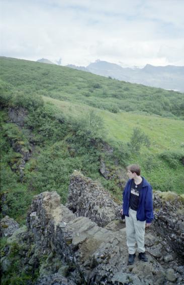 Dave standing on rocks above the river on the journey up to Svartifoss