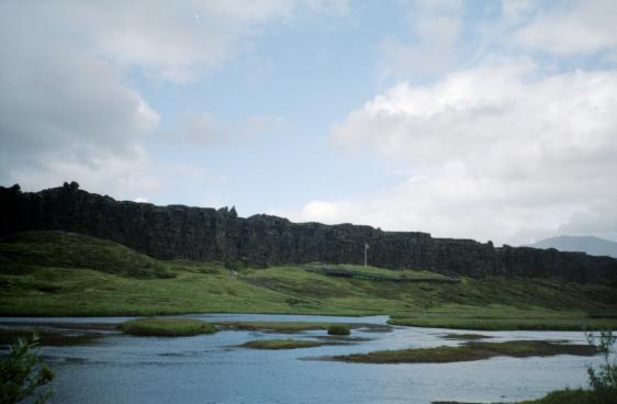 A view over the water to the flagpole and cliffs